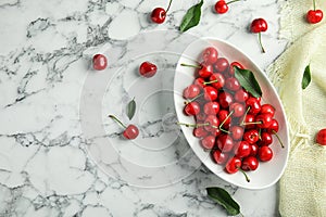 Bowl with sweet red cherries on marble table,