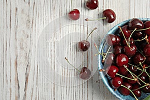 Bowl with sweet red cherries on wooden table