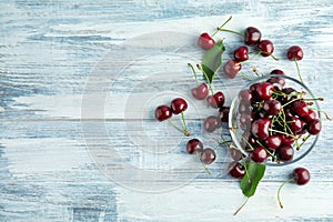Bowl with sweet red cherries on wooden table