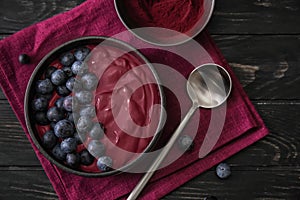 Bowl with tasty acai smoothie on wooden table