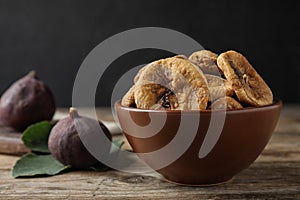 Bowl of tasty dried figs on wooden table