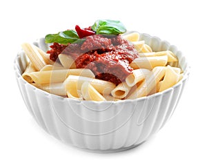 Bowl of tasty penne pasta with tomato sauce on white background