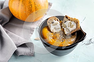 Bowl with tasty pumpkin cream soup on light table