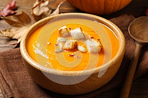 Bowl with tasty pumpkin cream soup on table