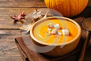 Bowl with tasty pumpkin cream soup on table