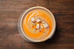 Bowl with tasty pumpkin cream soup on table, top view