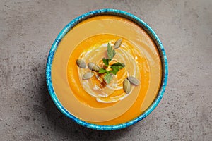 Bowl with tasty pumpkin soup on gray table