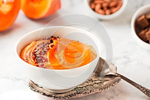 Bowl of tasty pumpkin soup ith chili flakes pepper, nuts and croutons.Space for text on marble table