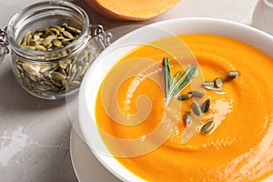 Bowl with tasty pumpkin soup served on table