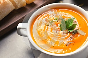 Bowl with tasty pumpkin soup served on table