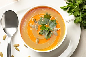 Bowl of tasty pumpkin soup on table , top view