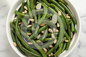 Bowl of tasty salad with green beans on white marble table, top view