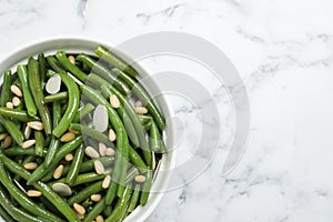 Bowl of tasty salad with green beans on white marble table, top view. Space for text