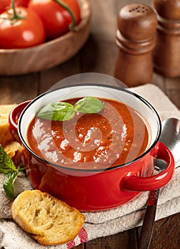 Bowl of tomato soup garnished with basil leaves