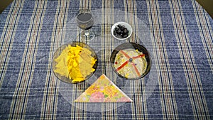 Bowl of tuna salad, tortilla chips, olives and glass of red wine
