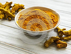 Bowl with turmeric powder and roots