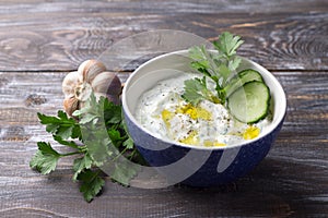 Bowl of tzatziki greek yogurt sauce on a wooden table