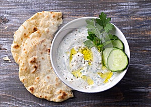 Bowl of tzatziki greek yogurt sauce on a wooden table