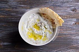 Bowl of tzatziki greek yogurt sauce on a wooden table