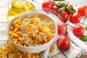 Bowl with uncooked pasta on table