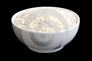 Bowl of uncooked white long grain rice on black.