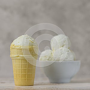 Bowl of vanilla ice cream on light background. Side view