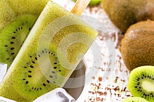 Bowl of vanilla and kiwi yogurt popsicles on a white rustic wooden background, unsweetened ice cream, natural homemade