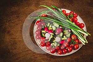 Bowl of vegetables on wooden background in top view