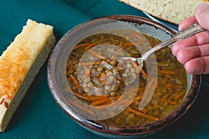 Bowl of vegetarian lentil soup with carrot, onion, and garlic. Served with delicious homemade cheese bread