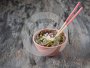Bowl with white rice and string beans with aromatic herbs in a pink bowl with wooden sticks