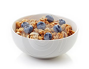 Bowl of whole grain muesli and blueberries isolated on white