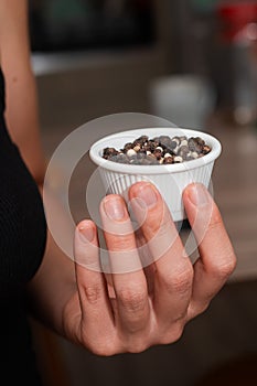 Bowl of Whole Peppercorns in a Female Hand. Gently holding a ramekin filled with assorted whole peppercorns