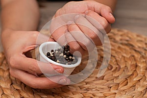 Bowl of Whole Peppercorns in a Female Hands. Gently holding a ramekin filled with assorted whole peppercorns