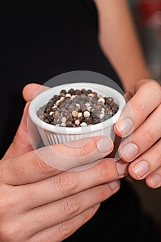 Bowl of Whole Peppercorns in a Female Hands. Gently holding a ramekin filled with assorted whole peppercorns