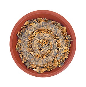 Bowl of wild harvested cherry tree bark on a white background.