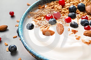 Bowl with yogurt, berries and granola on table