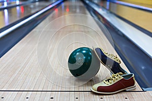 Bowling ball and shoes on lane background