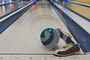 Bowling ball and shoes on lane background