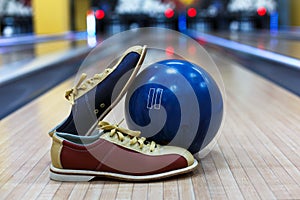 Bowling ball and shoes on lane background