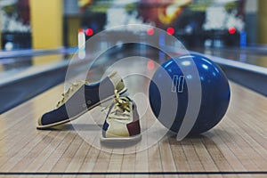 Bowling ball and shoes on lane background