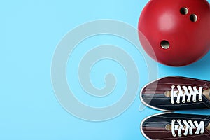 Bowling ball and shoes on blue background, flat lay. Space for text