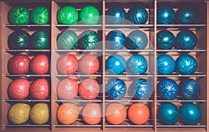 Bowling balls in the rack, sorted by color