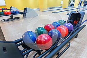 Bowling balls return machine, alley background