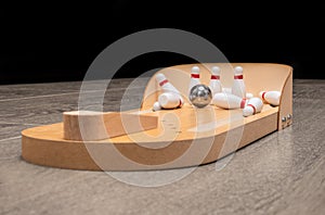 Bowling kit with white pieces on wooden board