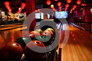 Bowling lane and balls in the row in bowling center.