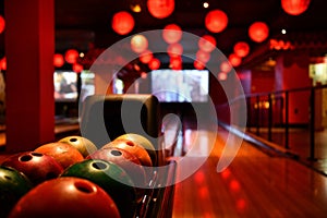 Bowling lane and balls in the row in bowling center.