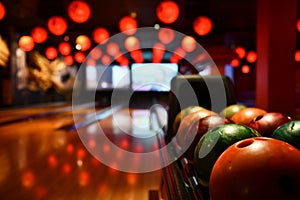 Bowling lane and balls in the row in bowling center.