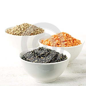 Bowls of assorted dried lentils with red lentils, black beluga l