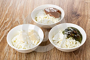 Bowls with cottage cheese, gooseberry jam, condensed milk, boiled condensed milk on table
