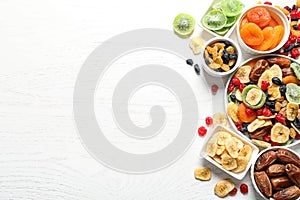 Bowls of different dried fruits on wooden background, space for text. Healthy lifestyle